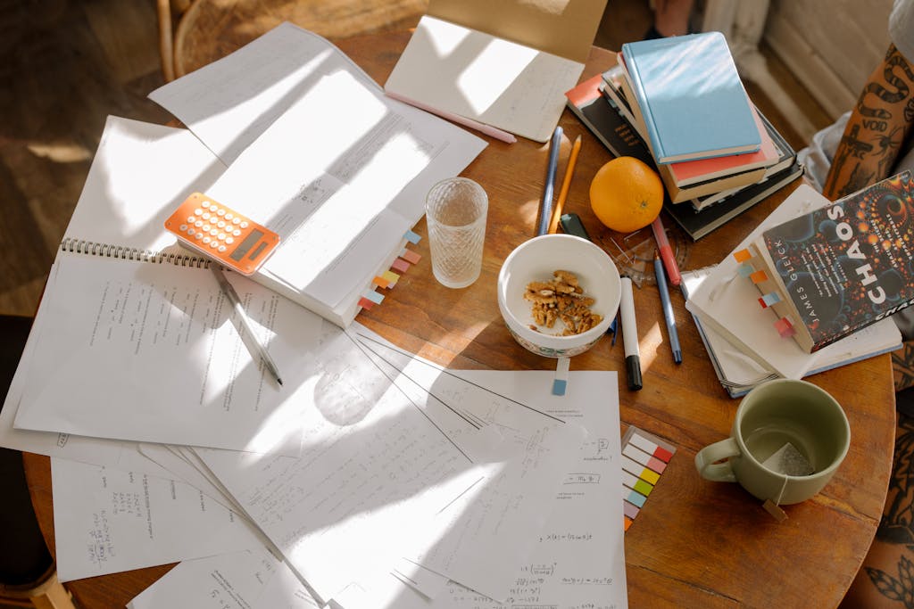 A cluttered study table with books, notes, and study materials in natural light for focused exam preparation.